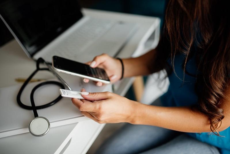 Nurse with smartphone and COVID test