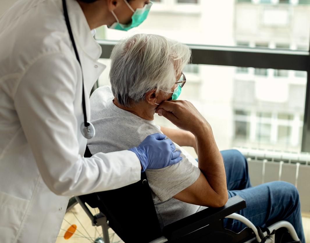 Nursing home patient in wheelchair with caregiver