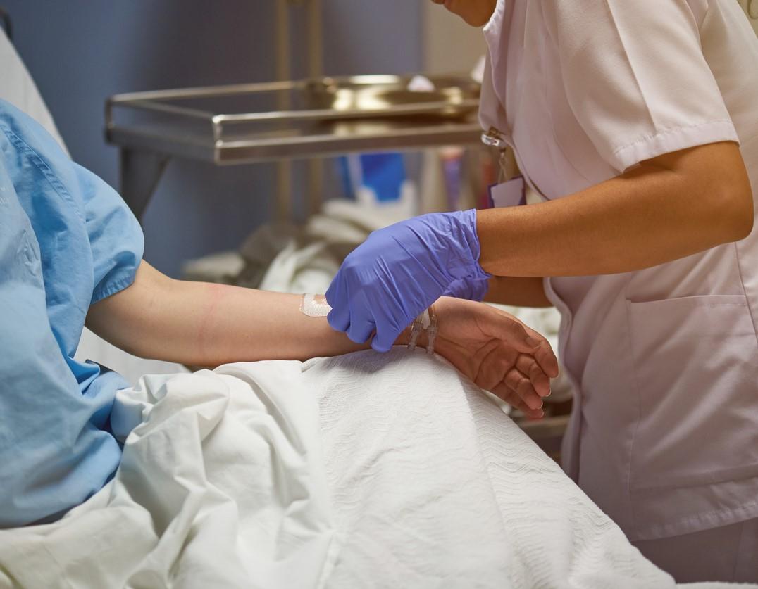 Nurse inserting catheter into arm