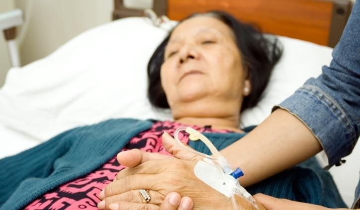 Older Asian woman in hospital bed