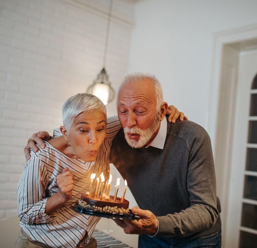 Older couple blowing out birthday candles