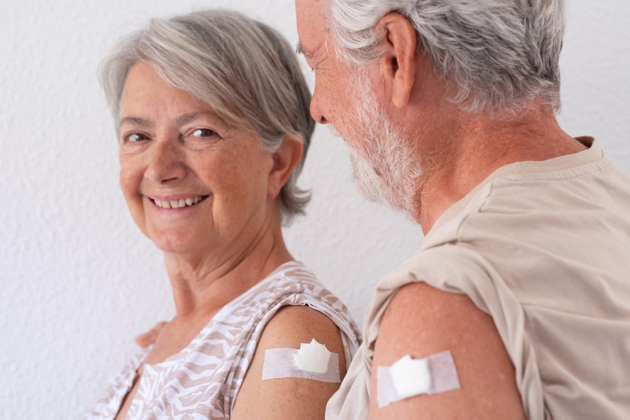Older couple with vaccine bandages on their arms