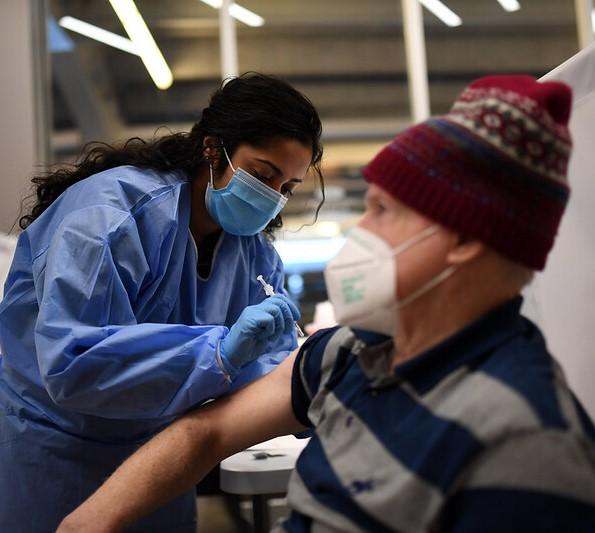 Older man with hat getting vaccinated