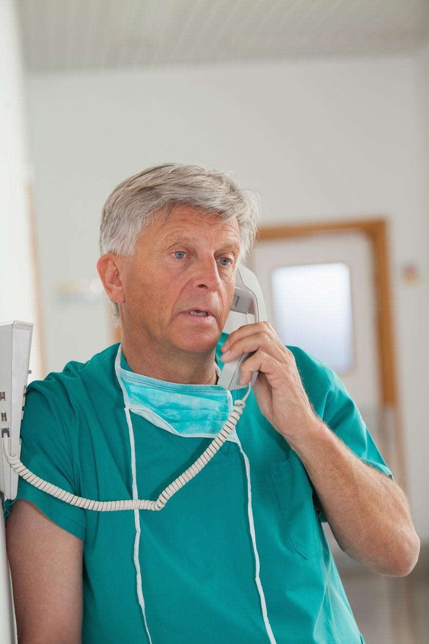 Older surgeon on phone
