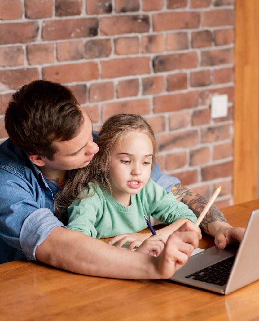 Daughter doing online learning with dad