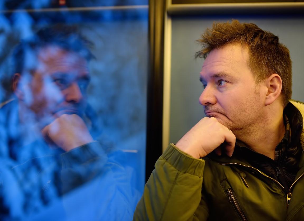 thoughtful man looking out train window