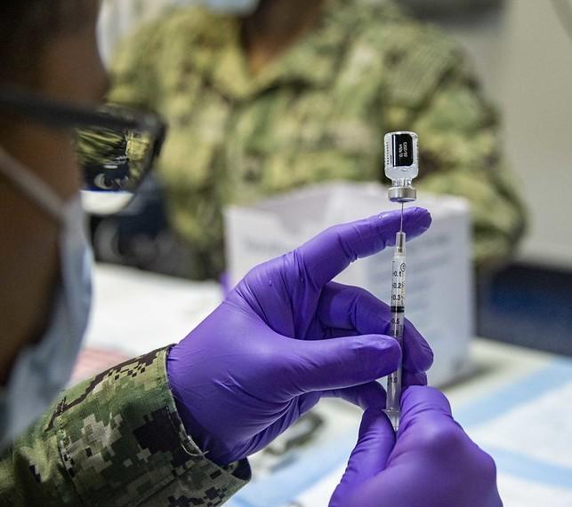Pfizer COVID vaccine vial drawing into syringe