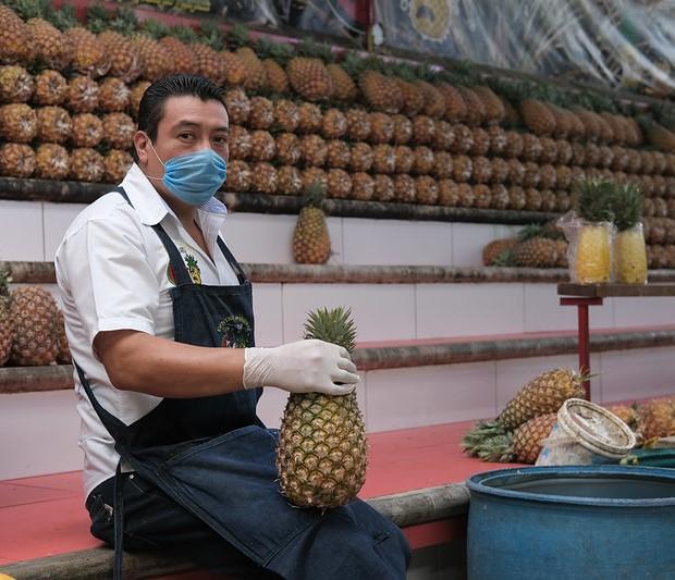 Pineapple seller wearing mask