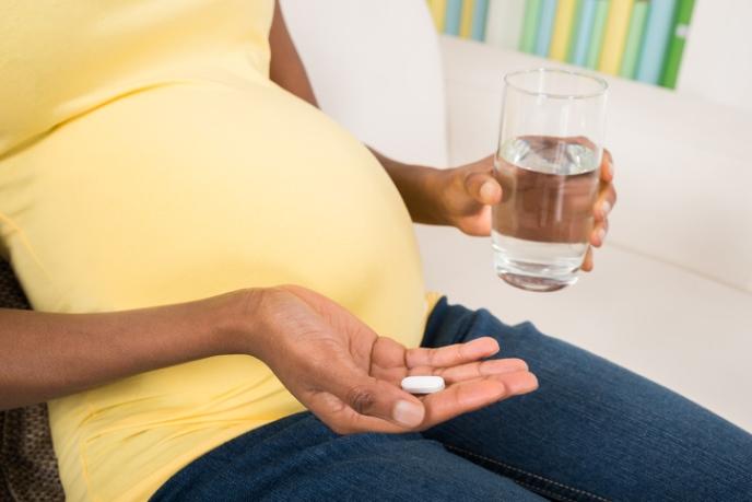 Pregnant woman taking pill