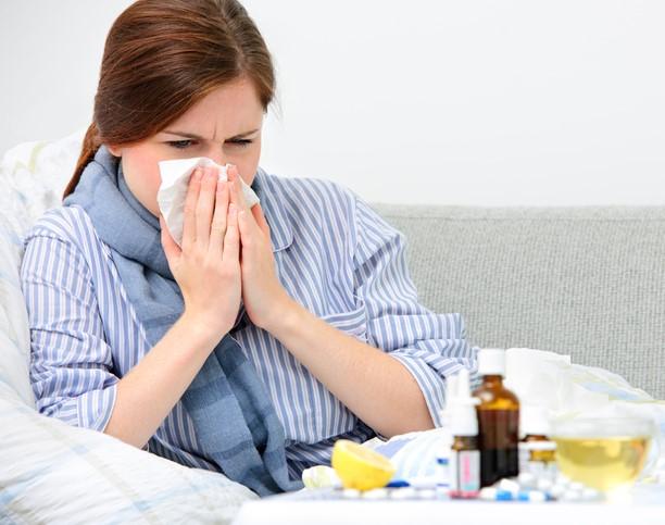 Sick woman blowing nose