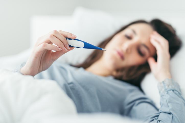 Sick woman taking temp