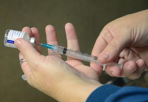 Syringe in flu vaccine vial