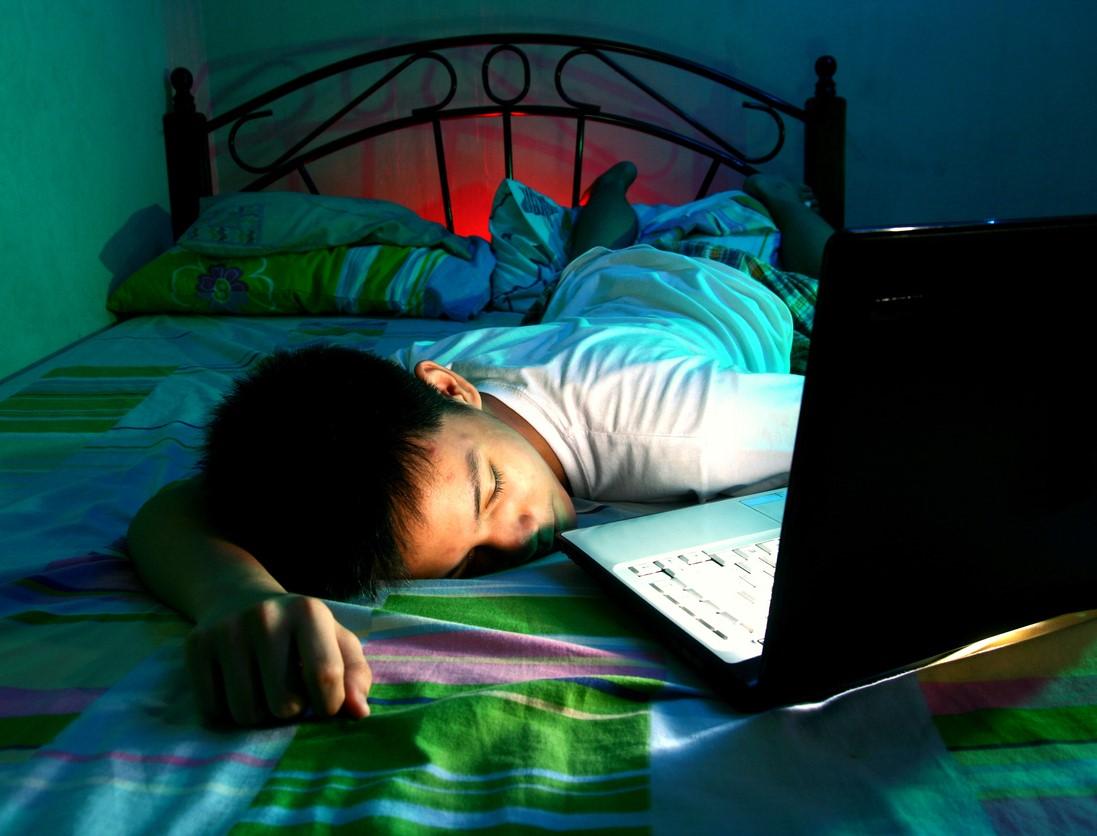 Teen asleep on bed with laptop