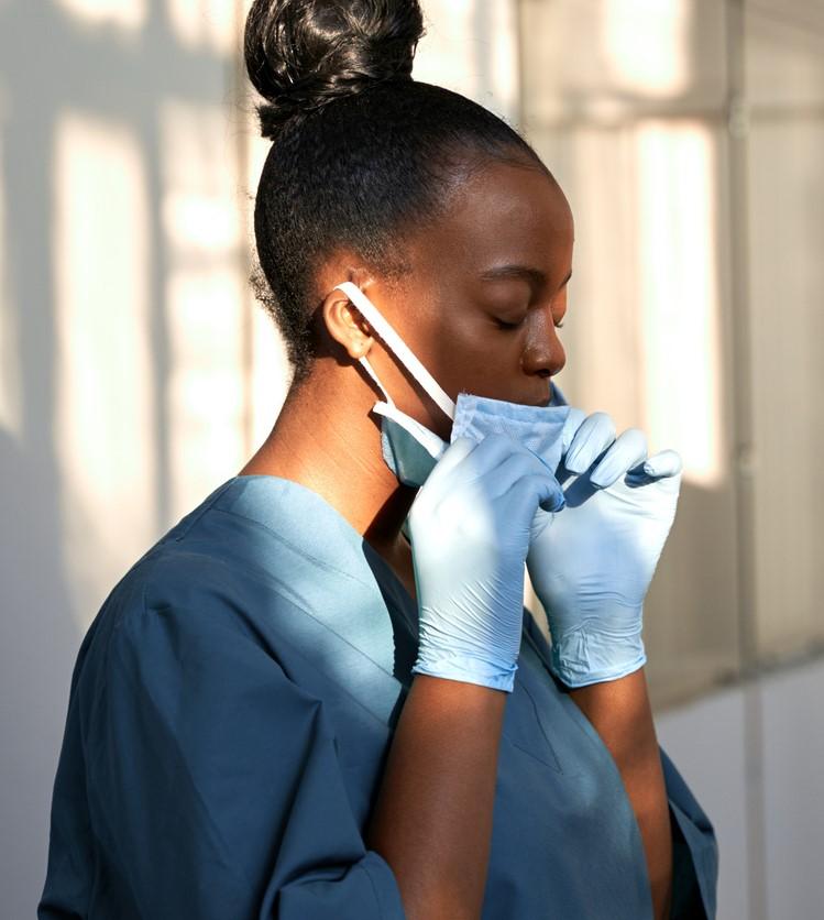 Tired nurse taking mask off