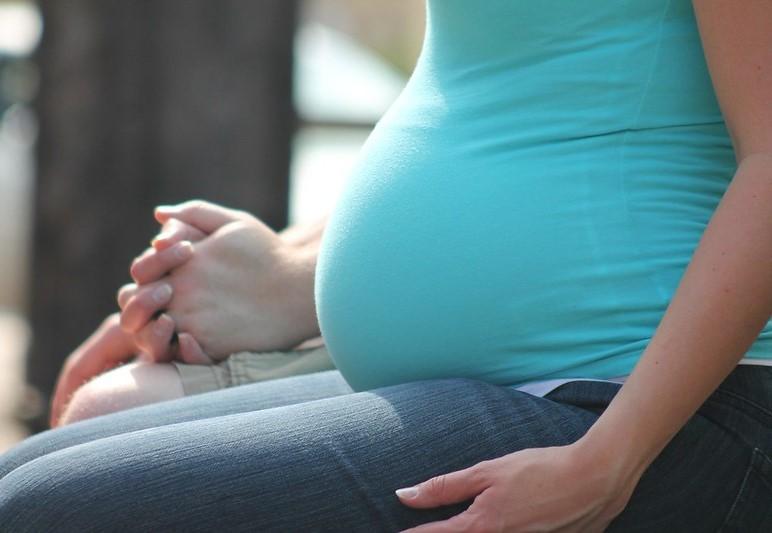 Torso of sitting pregnant woman