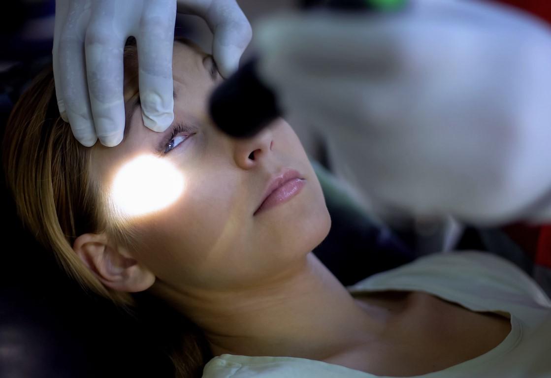 Pupil flashlight test on unconscious girl