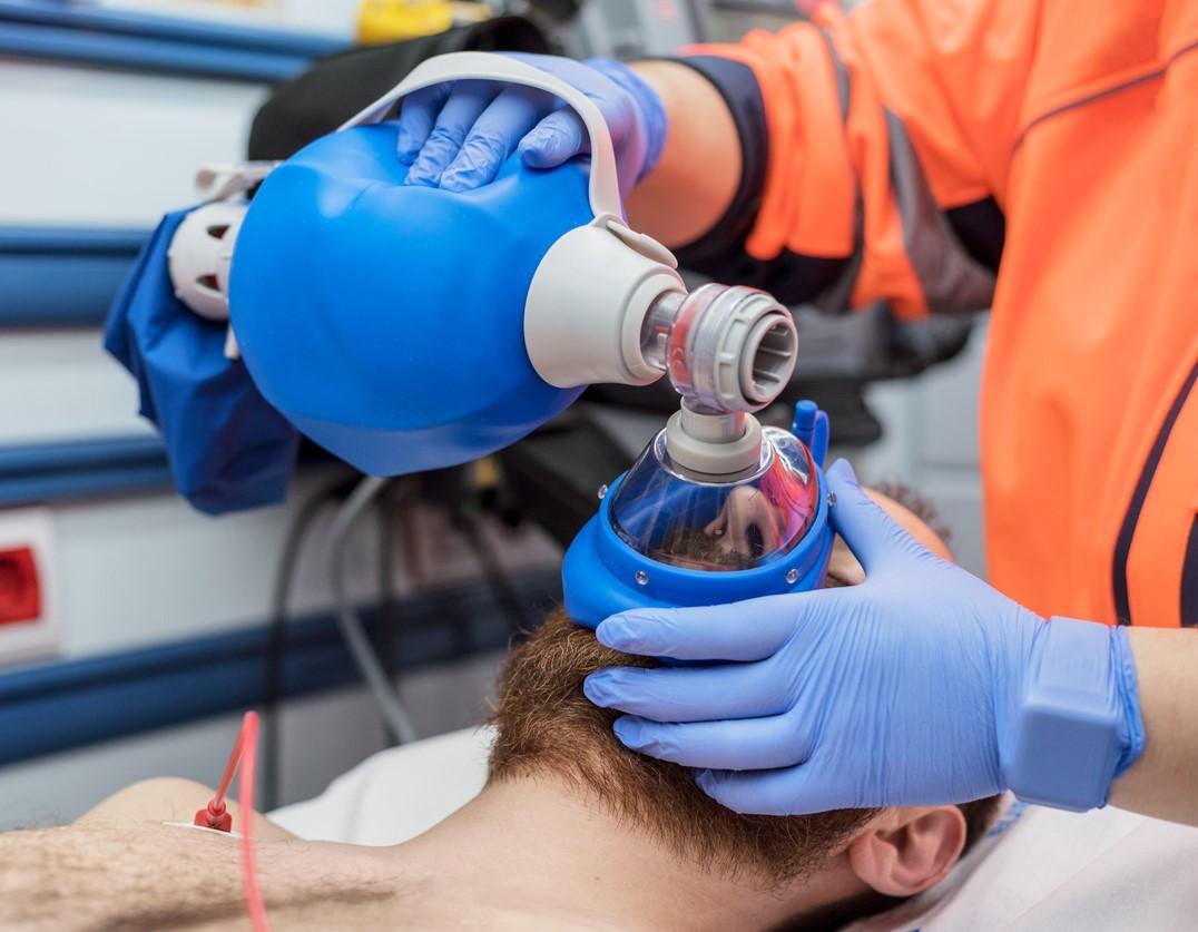 Paramedic using ambu bag on patient