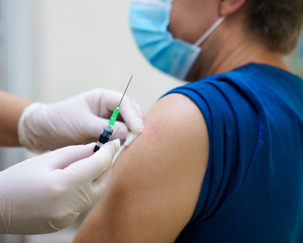 Preparing man's arm for vaccination