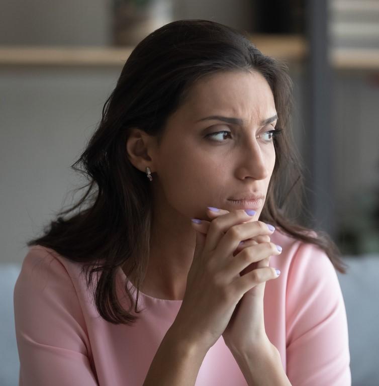 Woman appearing pensive and anxious