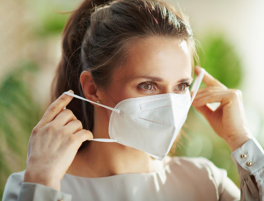 Woman putting on a respirator