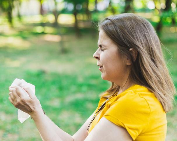 Woman sneezing outdoors