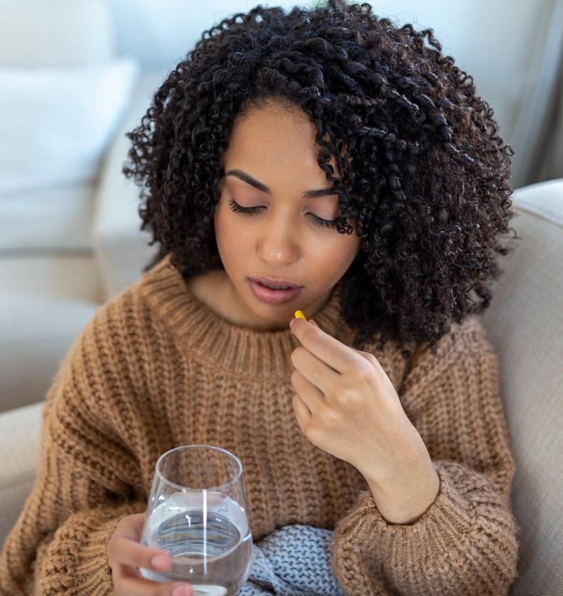 Woman taking drug capsule