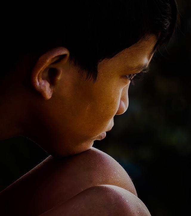 Young boy with chin on knee