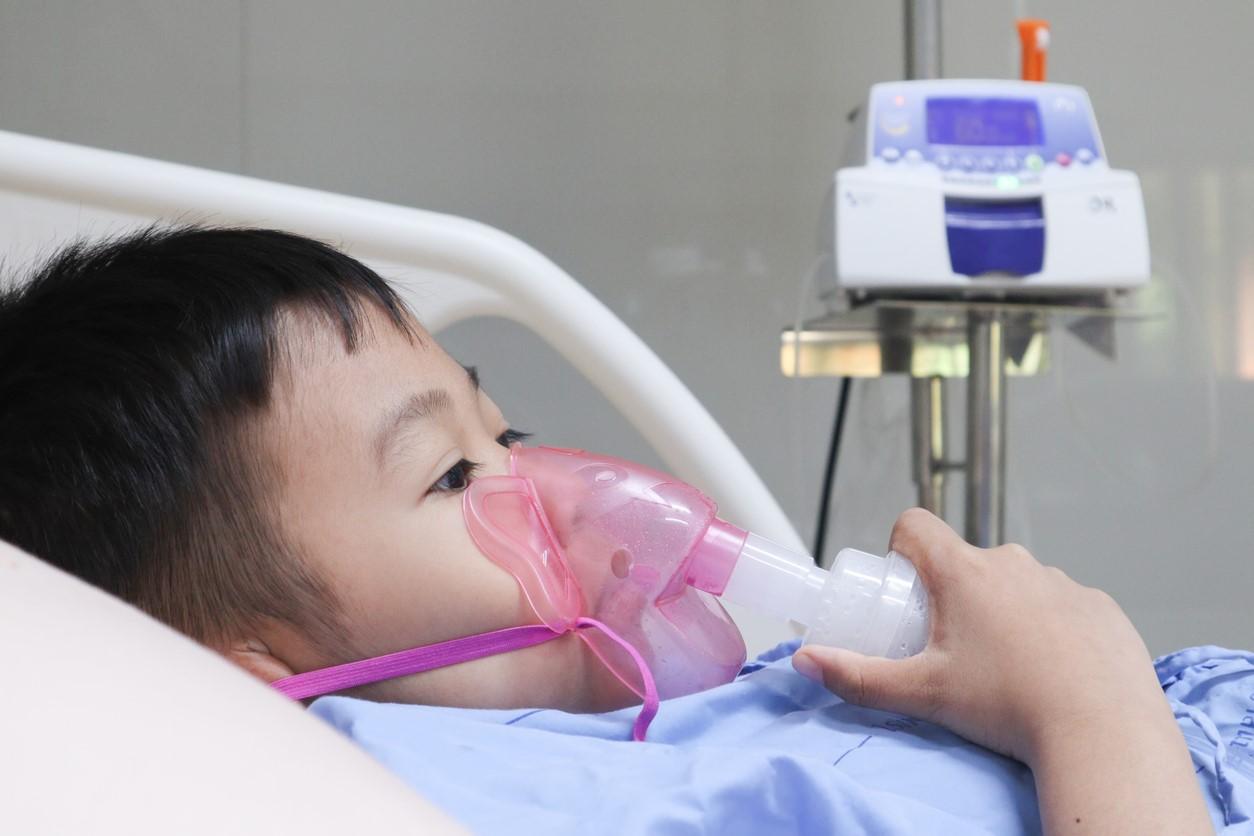 Young boy in hospital bed on oxygen
