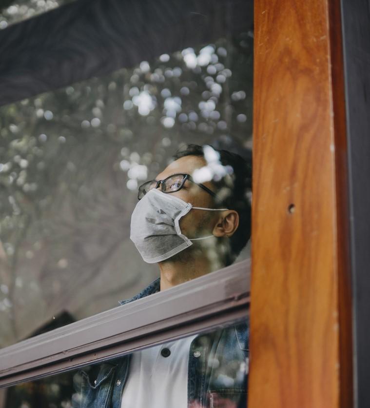 Young man wearing mask in window