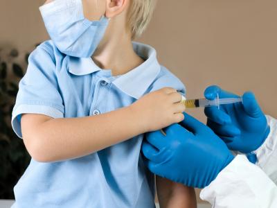 Boy in blue shirt getting vaccinated