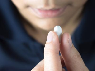 Close up of man taking a white caplet