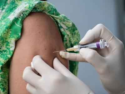 Girl in green dress being vaccinated