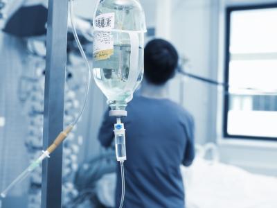 IV drip with healthcare worker in background