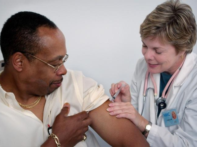 Nurse vaccinating man