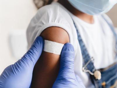 Little girl with post-vaccination bandage on arm