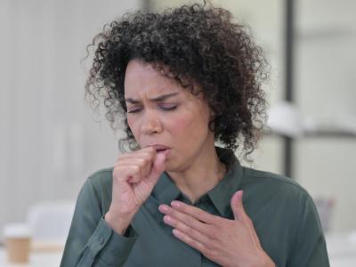 Woman coughing into hand