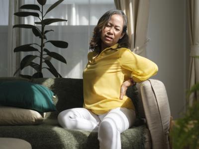 Woman with back pain on couch