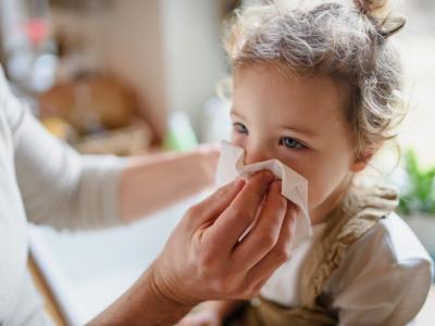 Young girl blowing nose