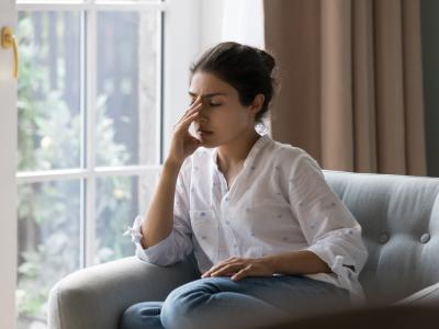 Young woman on couch with headache
