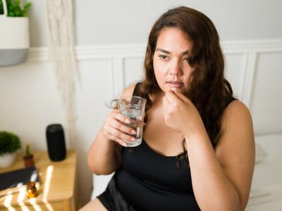 Young woman taking white pill