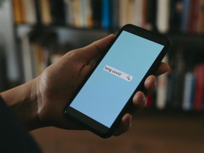 Person looking up long COVID on phone