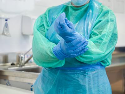 Healthcare worker in gown and gloves