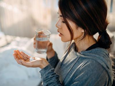Woman taking white tablets