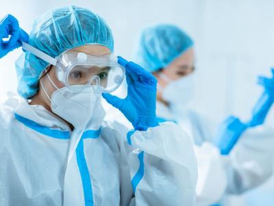 Asian doctors putting on personal protective equipment