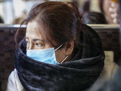 Asian woman wearing mask on bus