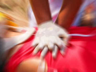 Gloved hands performing CPR