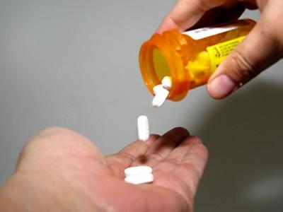 Pills dropping onto person's palm