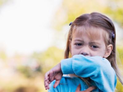 Child coughing into sleeve