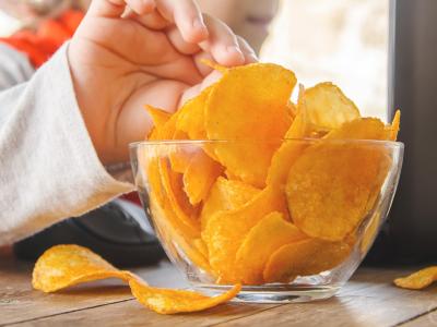 Child using computer while eating potato chips