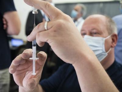 Clinic worker with vaccine vial and syringe